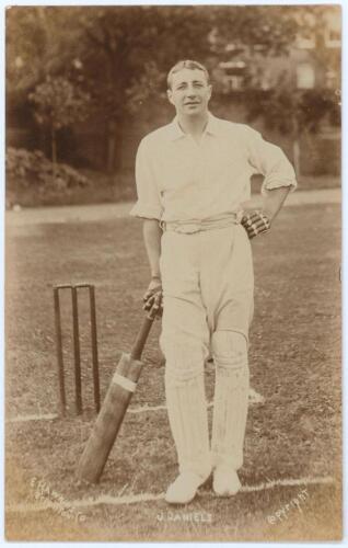 John Daniell. Somerset & Cambridge University 1898-1927. Early sepia real photograph postcard of Daniell standing full length at the wicket leaning on his bat. E. Hawkins & Co. of Brighton. Title to lower edge &lsquo;J. Daniels&rsquo;. Postally unused. Very good cond