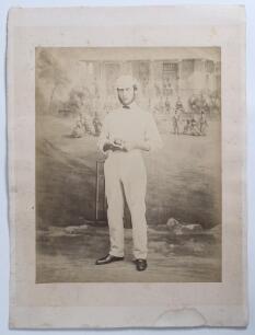 Edward Mills Grace. Gloucestershire, M.C.C. & England 1870-1896. Early large original sepia studio posed photograph of Grace in full cricket attire and wearing a cap, aged 21. The photograph, taken in 1862, shows Grace standing in front of a wicket holdin