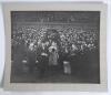 King George VI 1930s. A large original mono photograph of King George VI entering the field of an unknown sports stadium from a grandstand accompanied by dignitaries wearing formal attire and bowler hats. In the stands, large crowds are looking on enthusi
