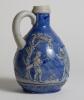 Golf jug. &lsquo;Ges Gesch&rsquo; German Blue Jug with scenes of golfers and caddies to sides. 7.5&rdquo; tall with full stamps to base. &lsquo;042&rsquo; to base. Good condition - 2