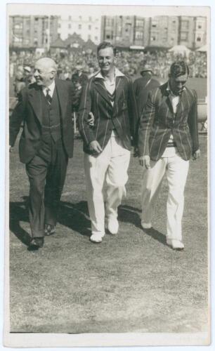 South Africa tour to England 1935. Mono real photograph postcard of South African players, Bruce Mitchell and Jock Cameron, walking off the field at Scarborough with H.D.G. Leveson-Gower, the players wearing tour blazers. Annotation in red ink to verso st