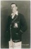William Howard Vincent &lsquo;Hopper&rsquo; Levett. Kent & England 1930-1947. Mono real photograph studio portrait postcard of Levett standing three quarter length wearing M.C.C. blazer for the tour to India 1933/34. B.C. Flemons of Tonbridge. Signed by Levett to the
