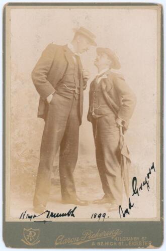 Hugh Trumble and Syd Gregory. Australia tour to England 1899. Excellent sepia cabinet card photograph of a tall Hugh Trumble looking down on Syd Gregory, both depicted full length wearing formal attire, straw boaters, and smoking cigarettes, Gregory leani