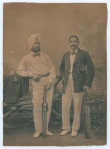 Kumar Shri Ranjitsinhji. Cambridge University, Sussex, London County & England 1893-1920. Original sepia studio portrait photograph of Ranji standing full length alongside another Indian cricketer in a turban. Both players wearing cricket attire and bow t
