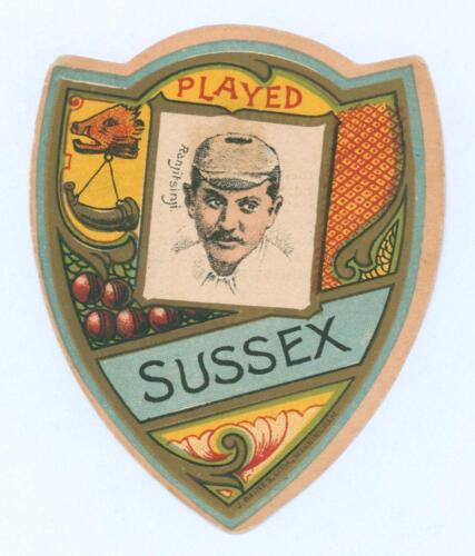 Kumar Shri Ranjitsinhji. Cambridge University, Sussex, London County & England 1893-1920. Rare colour shield-shaped card by J. Baines Litho of Bradford c.1895 depicting Ranjitsinhji with &lsquo;Played Sussex&rsquo; above and below. Advertising to verso. Small adhesiv