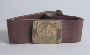&lsquo;Cricket&rsquo;. Early and complete red material belt with excellent oblong brass belt buckle with embossed cricketer wearing boater style hat and cricket attire holding a ball with banner beneath &lsquo;Cricket&rsquo;. Cricket bat and ball decoration to each of the side 
