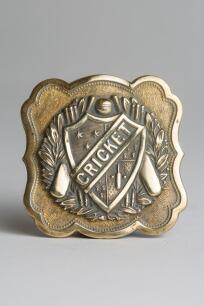 &lsquo;Cricket&rsquo;. Early and exquisite Victorian embossed square brass belt buckle, with clasp to back, decorated to centre with a winners garland, bats, ball and wickets and to the very centre with the title &lsquo;Cricket&rsquo; circa 1860/70&rsquo;s. Decorative patterned border