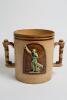 Doulton Lambeth Large, than normal, stoneware two handled loving cup, in brown with a swirling lined floral decoration in white, with two moulded relief vignettes in roundels of a batsman leaning on his bat and a fielder catching the ball on a brown backg