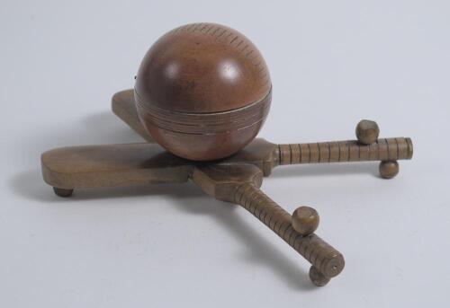 Cricket ball inkwell. An attractive Victorian wooden inkwell modelled as a cricket ball and supported by wooden crossed cricket bats with grooved pen holders and balled feet support. Approximately 6&rdquo; x 4.5&rdquo; wide. G