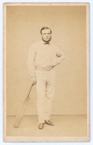 Robert Pearson Carpenter. Cambridgeshire & United England 1861-1876. Rare and early original sepia carte de visite studio photograph of Carpenter standing full length wearing cricket attire including spotted shirt, leaning on a bat. The card with printed 