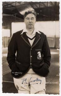 Frank Edward Woolley. Kent & England 1906-1938. Mono real photograph postcard of Woolley standing three quarter length wearing an M.C.C. blazer for the 1929/30 tour to New Zealand. Nicely signed in ink to the photograph by Woolley. B.C. Flemons of Tonbrid