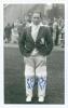 Stewart Cathie &lsquo;Billy&rsquo; Griffith. Cambridge University, Surrey, Sussex & England 1934-1954. Mono real photograph plain back postcard of Griffith standing full length wearing cricket attire and M.C.C. tour blazer. Nicely signed in blue ink to the photograph