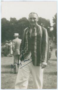 Albert John &lsquo;Jack&rsquo; Holmes. Sussex 1922-1939. Sepia real photograph postcard of Holmes depicted standing three quarter length wearing cricket attire and blazer. Nicely signed in ink to the photograph by Holmes. The postcard has been laid to tightly trimmed