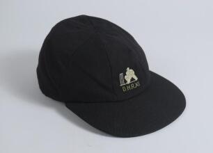 Derrick Robins XI navy blue cloth cricket cap, by Michael of Chatham, with embroidered emblem with &lsquo;D.H.R. XI&rsquo; below to front. Appears match worn, good condition. Ownership unknown.
