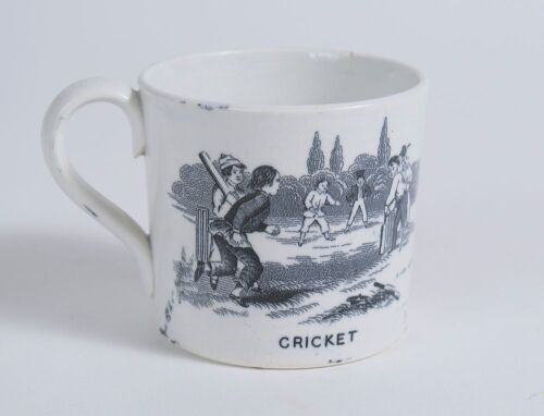 &lsquo;Cricket&rsquo; and &lsquo;Leap Frog&rsquo;. Victorian Staffordshire cricket mug with strap handle, transfer printed in black with images of an early cricket scene with boys playing cricket with title &lsquo;cricket&rsquo; below and to the other side a scene of boys playing Leap Frog 