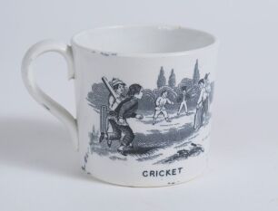 &lsquo;Cricket&rsquo; and &lsquo;Leap Frog&rsquo;. Victorian Staffordshire cricket mug with strap handle, transfer printed in black with images of an early cricket scene with boys playing cricket with title &lsquo;cricket&rsquo; below and to the other side a scene of boys playing Leap Frog 