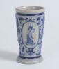 Westerwald stoneware cricket beaker, moulded in relief with three cameo panels of a batsman, after W.G. Grace, in different poses. The body highly decorated with vine and sprig decoration in cobalt blue on a grey background, with the figures highlighted i