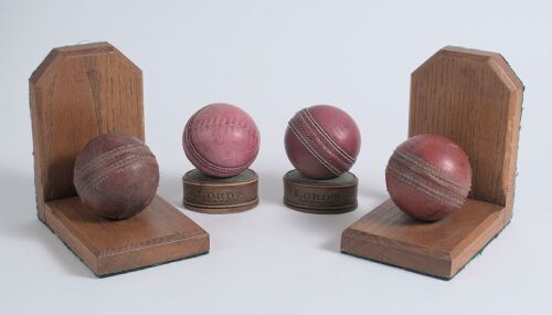 Cricket ball bookends. Two pairs of book ends, one produced and sold by Lord&rsquo;s and the other with cricket balls mounted on varnished wooded ends. Good condition