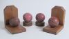 Cricket ball bookends. Two pairs of book ends, one produced and sold by Lord&rsquo;s and the other with cricket balls mounted on varnished wooded ends. Good condition