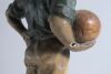 &lsquo;The Captain&rsquo;. Early plaster figure of a boy in football attire holding a brown football to side with hand on his hip. The boy is wearing a green jersey, yellow shorts, green socks and green cap. &lsquo;Captain&rsquo; inscribed to the chest of the boy&rsquo;s jersey. To ba - 3