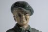 &lsquo;The Captain&rsquo;. Early plaster figure of a boy in football attire holding a brown football to side with hand on his hip. The boy is wearing a green jersey, yellow shorts, green socks and green cap. &lsquo;Captain&rsquo; inscribed to the chest of the boy&rsquo;s jersey. To ba - 5