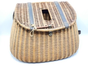 A French reed trout fisher's creel of sloping form, leather strapped back and lid with rectangular fish hole, treen pin brass lock with circular locking disc, canvas and leather shoulder strap, 17" wide, circa 1900