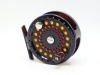 A Sage 5300 trout fly reel and spare spool, left hand wind, black anodised model with counter-balanced rosewood handle, block foot, rear spindle mounted milled tension adjuster, only very light use, in original neoprene cases
