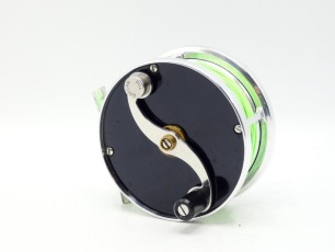 A good Bill Ballan Heirloom Wide 3 &frac14;" trout fly reel, left hand wind, composition handle on counter-balanced "S" scroll arm set within an anti-foul rim, black anodised end plates, pierced alloy foot, triple cage pillars, fixed check mechanism, little use