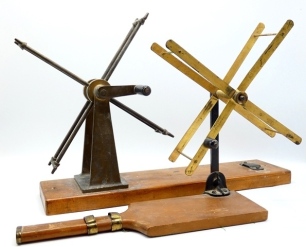 A Farlow Wilson-Wetherall line drier, collapsible folding brass arms, one with horn winding handle, brass sliding reel fitting and oak racquet shaped base, winding arm stamped makers name and Holdfast logo, circa 1915 and an un-named heavy brass line wind