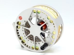 A Lamson Velocity 3.5x salmon fly reel and spare spool, silver anodised finish, large arbour skeletal drum with composition handle, block foot, rear spindle mounted tension adjusting wheel, only very light signs of use, in neoprene cases and card boxes