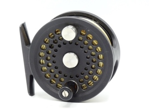 An Abel No.0 trout fly reel, right hand wind matt black anodised finish model, counter-balanced wooden handle, block foot, rear spindle mounted milled tension adjuster, only very light signs of use, in pouch and card box