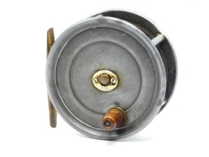 An early Hardy Uniqua 4 &frac14;" salmon fly reel, tapered horn handle, brass foot, drum withy four rim cusps and oval nickel silver "Oil" drum release latch, fixed 1906 calliper spring check mechanism, wear from normal use, circa 1909