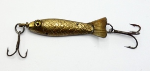 An un-named (Gregory?) 19th Century 2" metal bait, the fish shaped hollow white metal lure with curved tail, clear/black spot amber glass eyes, incised scale decoration, central revolving spindle with rear and front trebles and pierced to take two furthe