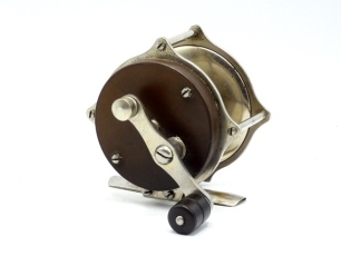 An un-named American 3 &frac12;" raised pillar bass multiplier reel, ebonite and nickel silvered construction with off-set counter-balanced handle, triple raised drum pillars, bridge foot, stamped "0", rear sliding optional check button, circa 1900