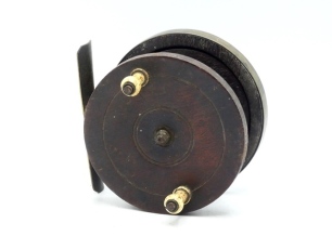 A scarce early Nottingham spine back 3 &frac12;" centre pin reel, solid mahogany drum with twin slender baluster bone handles and circular iron locking nut, brass bound rear plate, rivetted brass foot on iron support, one hairline crack to backplate, no check m