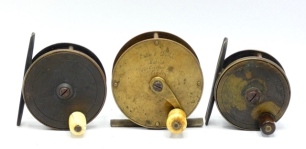 An Eaton & Deller brass 2 &frac34;" trout crank winch, turned bone handle on curved crank winding arm with dome iron retaining screw, rear raised check housing, fixed check, faceplate script engraved makers details, circa 1870 and two Farlow brass plate wind tro