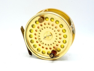 A Hardy Sovereign 11/12 salmon fly reel, gold anodised finish, counter-balanced rosewood handle, two screw drum latch, ribbed brass foot, rear sliding optional check button and spindle mounted tension adjuster, fine hairline crack across name stamp on ba
