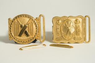 Cricket belt buckles. A pair of belt buckles, both mint tradesman&rsquo;s samples, and unused, in soft gilt metal. The first, with legend &lsquo;Our Game&rsquo;, of rectangular form with crossed bats to centre, stumps and cricket balls to sides with beaded border, the othe