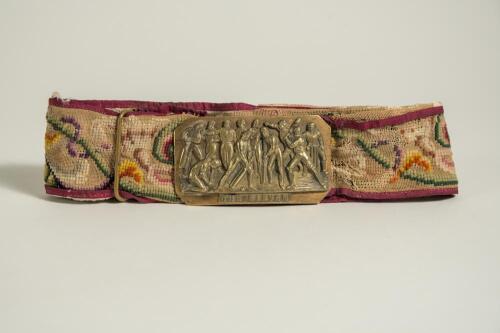 &lsquo;The Eleven&rsquo;. Early and complete embroidered belt with oblong shaped brass belt buckle showing the eleven players, shown as batsmen, fielders, bowlers and wicket-keeper, with legend to lower border. The buckle measures almost 3.5&rdquo;x2&rdquo;. The colourful belt e