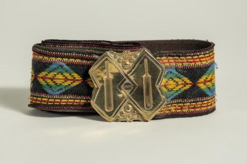Cricket belt. Early and embroidered belt with square irregular shaped brass belt buckle with image of two bats, each sectionalised with cricket ball decoration in between them. The buckle measures approximately 2&rdquo; square. . The colourful belt in a multitu