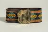 Cricket belt. Early and embroidered belt with square irregular shaped brass belt buckle with image of two bats, each sectionalised with cricket ball decoration in between them. The buckle measures approximately 2&rdquo; square. . The colourful belt in a multitu