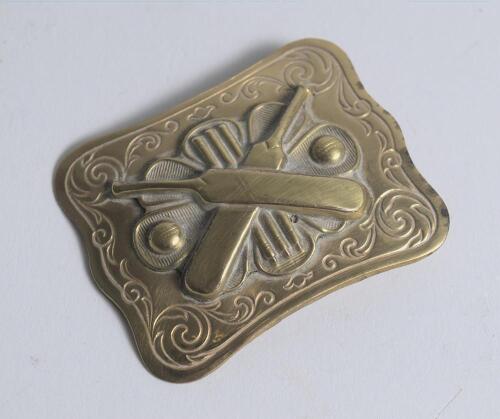 Belt buckle. Early and exquisite Victorian embossed oblong brass belt buckle, with clasp and flat hook to back, decorated to centre with crossed bats, stumps and two balls circa 1860/70&rsquo;s Decorative swirling borders. Approximately 2.5&rdquo;x2&rdquo;. Very good/excel