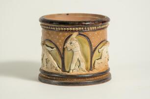 Doulton Lambeth stoneware tobacco jar, hand decorated with six moulded relief vignettes of cricketers to each arched roundel, three in various batting poses, one in wicket-keeping pose and two in fielding pose with an impressed overall flower motif on the