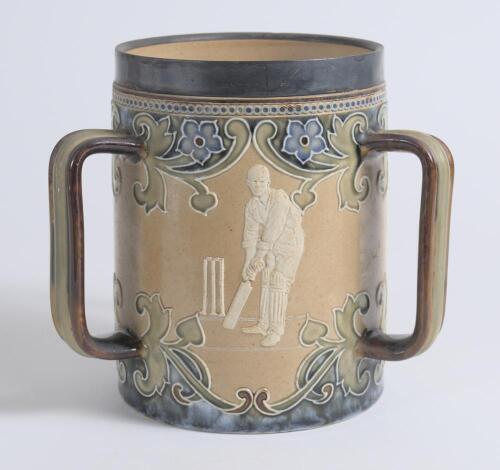 Doulton Lambeth stoneware tyg. Large, than normal, and impressive three handled tyg with three moulded relief vignettes of cricketers, a batsman, a fielder and wicket keeper in white on a brown background with stylised floral leaf and flower Art Nouveau d