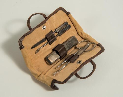 Leather cricket bag manicure set. An exquisite miniature real leather cricket bag with stud connector which opens up to reveal a full and complete five piece manicure set including nail buffer, pair of nail scissors, file etc. Each with strapping to hold 