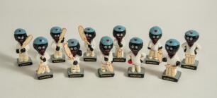 Robertson golliwog cricketers. Eleven different figures wearing cricket attire and blue caps, including eight batsmen in varying poses, one bowler and two wicket- keepers. Each approx. 2.5&rdquo; tall with &lsquo;Robertson&rsquo; to base. Date unknown. Minor wear, odd chip