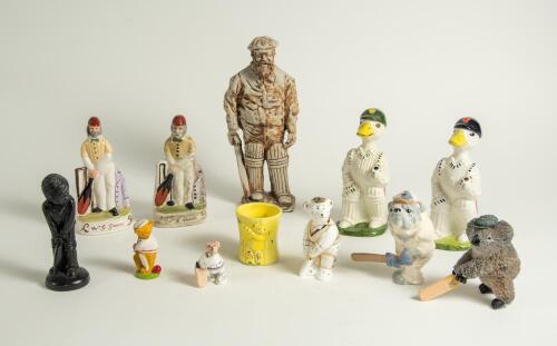 Cricket ceramics and metalware. Varied selection of items including modern metal figures of cricketers, a pair of cricket wicket bookends, a boy cricketer made out of slate, two cricket duck batsman by Acorn Ceramics, a bulldog batsman, a golliwog egg cup