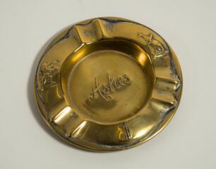 &lsquo;Ashes&rsquo;. Brass ashtray with title impressed to centre, to side rims images of a kangaroo with bat under his arm and lion tossing a ball into the air and to lower rim a set of three stumps and cricket ball. 3.75&rdquo; diameter. Some wear otherwise in good condi