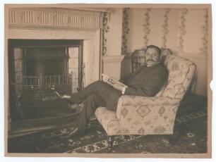 Kumar Shri Ranjitsinhji. Cambridge University, Sussex, London County & England 1893-1920. Excellent original sepia photograph of Ranjitsinhji in casual pose wearing suit and tie, seated in an armchair holding a magazine in front of a fireplace. The unmoun