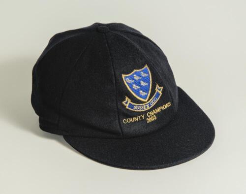 &lsquo;Sussex C.C.C. County Champions 2003&rsquo;. Navy blue cricket cap, by Albion, produced to commemorate the Championship win, with &lsquo;Sussex C.C.C.&rsquo; and Sussex Martlet emblem and &lsquo;Sussex C.C.C. County Champions 2003&rsquo; embroidered in gold thread to front. Signed int